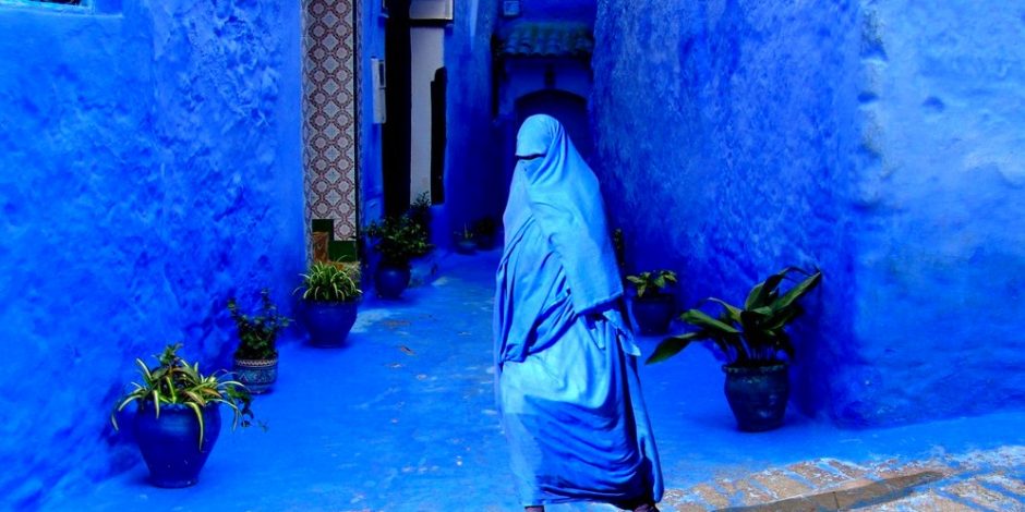 veiled woman walking in chefchaouen street